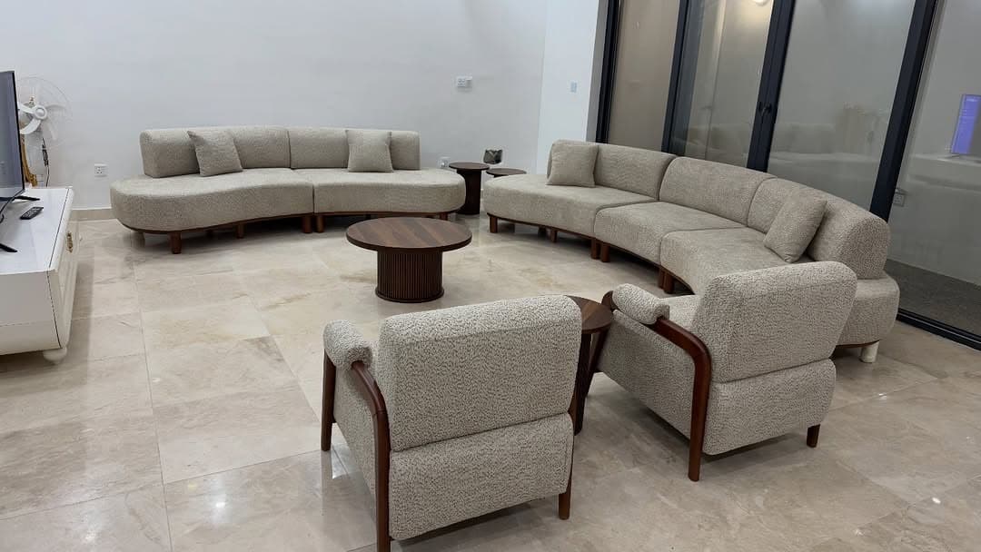 Curved cream boucle sectional sofa with solid walnut frame in a styled living room